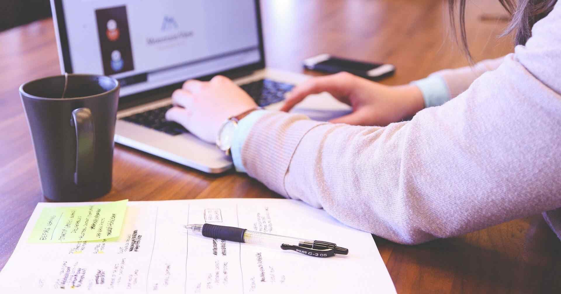 Working through questions on a laptop with handwritten notes